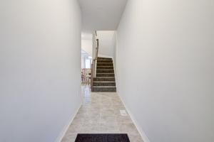a hallway of a house with white walls and stairs at Niagara Falls Luxury Living - 8 GUEST HOUSE in Niagara Falls
