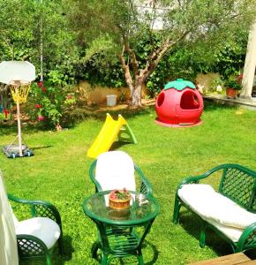 um quintal com uma mesa e cadeiras e um parque infantil em Apartment Villa Panorama em Tessalônica