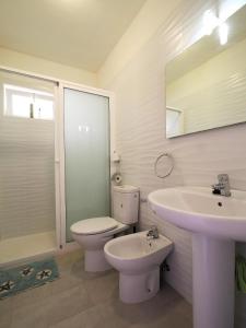 Baño blanco con aseo y lavamanos en Casa Nicole, en Caleta de Fuste