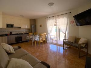 a living room with a couch and a table with chairs at Casa Nicole in Caleta De Fuste