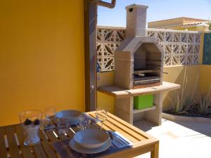 a table with a pizza oven on a patio at Casa Nicole in Caleta De Fuste