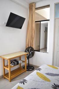 Hospedaje El Buen Samaritano في باراكاس: غرفة نوم مع مكتب ومرآة