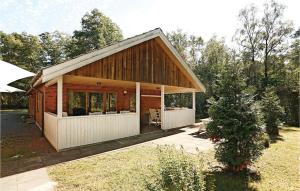 Cabaña de madera con porche en un patio en Amazing Home In Nex With Wifi, en Spidsegård