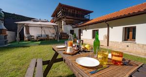 einen Picknicktisch im Hof mit einer Flasche Wein in der Unterkunft La casina de Peñaullan in Pravia