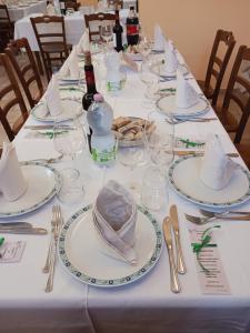 uma mesa longa com pratos e garrafas de vinho e copos em Agriturismo Vemi em Santa Sofia dʼEpiro
