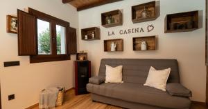 ein Wohnzimmer mit einem grauen Sofa und einem Fenster in der Unterkunft La casina de Peñaullan in Pravia