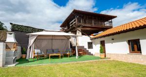 eine Terrasse mit einem Tisch und Stühlen unter einem Sonnenschirm in der Unterkunft La casina de Peñaullan in Pravia