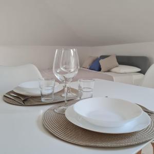 una mesa blanca con platos y vasos. en Gate 25 en San Giovanni Teatino