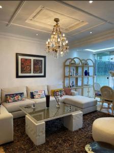 a living room with a couch and a chandelier at Villa 3 chambres piscine marinasmir in Tétouan