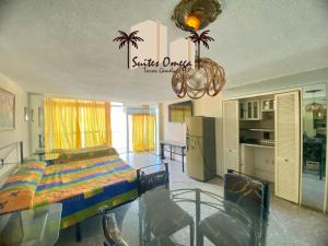 ein Schlafzimmer mit einem Bett und Stühlen in einem Zimmer in der Unterkunft Suites Omega Torres Gemelas in Acapulco