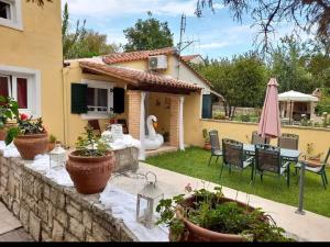 a backyard with a table and chairs and a house at dasia apartments in Dassia