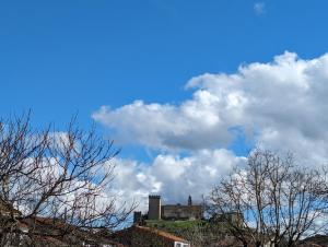 um castelo numa colina sob um céu nublado em Noly Apartamento em Monforte de Lemos