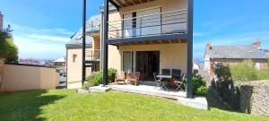 ein Haus mit einem Balkon mit einem Tisch und Stühlen in der Unterkunft Centre du Val André - appart en rez de jardin avec terrasse et jardinet - plage à 150 m in Pléneuf-Val-André