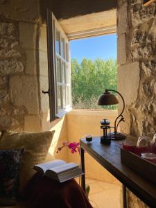 a room with a table with a lamp and a window at Château de Monsac in Monsac
