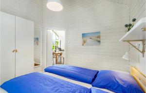 uma cama com almofadas azuis num quarto branco em Beautiful Home In Krems Ii-warderbrck With Kitchen em Göls