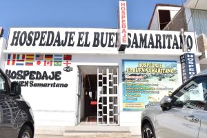 Hospedaje El Buen Samaritano في باراكاس: مبنى ابيض عليه لافته على الواجهه