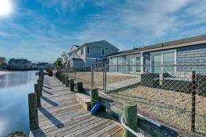 ein Haus auf einem Dock neben einem Gewässer in der Unterkunft Mystic Island waterfront oasis in Little Egg Harbor Township