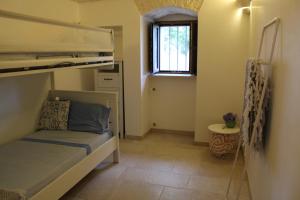 een kleine slaapkamer met een stapelbed en een raam bij La Cummersa all'ombra dell'Ulivo in Locorotondo
