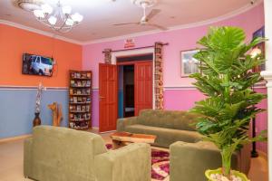 a living room with a couch and a plant at Dominion Embassy Lodge in Sekondi-Takoradi