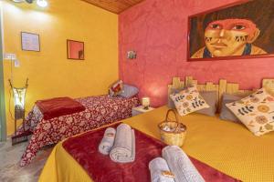a bedroom with two beds and a painting on the wall at Casa "a chiazzetta" in Castelbuono