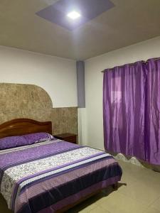 1 dormitorio con cama y cortinas moradas en Casa en san Cristobal en Puerto Baquerizo Moreno