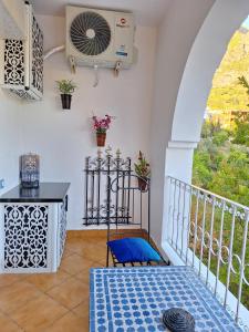a balcony with a fan and a table at Casa Ras El Maa in Chefchaouene