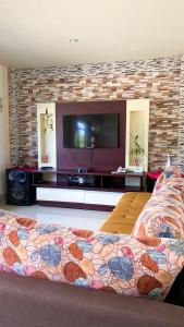 Casa en san Cristobal في بويرتو بكويريزو مورينو: غرفة معيشة مع تلفزيون بشاشة مسطحة وسرير