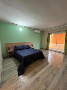 ein Schlafzimmer mit einem Bett in einem Zimmer mit grünen Wänden in der Unterkunft Complejo Aloe Vera D in Villa Dolores