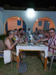 阿布辛貝的住宿－Hllol Hotel Abu Simbel，一群坐在餐桌旁吃饭的人