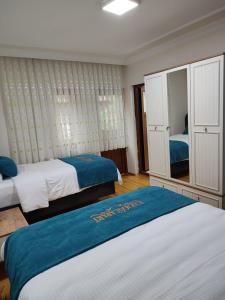 1 dormitorio con 2 camas y espejo en Karagoz Apart Pansiyon en Uzungol