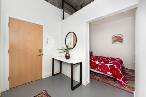 MainevilleにあるNew Industrial Loft Space on River and Bike Trailのベッドルーム1室(ベッド1台、鏡、テーブル付)