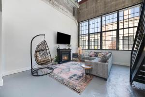 MainevilleにあるNew Industrial Loft Space on River and Bike Trailのソファと暖炉のあるリビングルーム