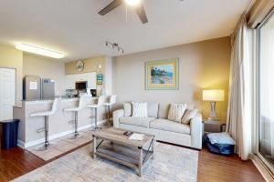 a living room with a couch and a kitchen at Shores of Panama 1507 in Panama City Beach