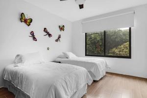 two beds in a room with butterflies on the wall at Ms Magnifica Suite Ubicadisima 119B in Casa Blanca La Corregidora