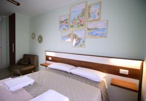 een slaapkamer met een bed en een stoel en foto's aan de muur bij MALUSI B&B in Napels