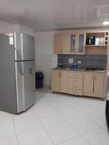 uma cozinha com um frigorífico de aço inoxidável e armários em HABITACIÓN PRIVADA tranquila y confortable em Bello