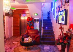 vestíbulo con escalera, sofá y mesa en Definite Destiny Hotel by YOTRAD en Lagos