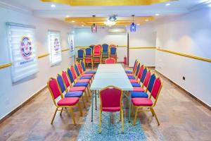 Definite Destiny Hotel by YOTRAD في لاغوس: قاعة المؤتمرات مع طاولة وكراسي طويلة