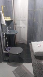 a bathroom with a toilet and a sink at Pousada Bora Bora in Guarapari
