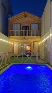 una casa con piscina por la noche en درة العروس اكواخ الدره en Durat  Alarous