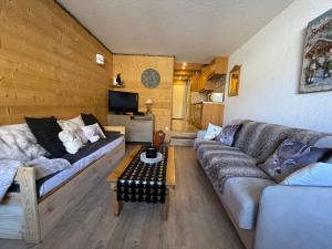 a living room with a couch and a table at Isola 2000 centre galerie 6 couchage 35m2 aux pieds des pistes in Isola 2000