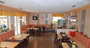 a restaurant with wooden tables and chairs and tables and tablesktop at Casa Montana in Niedernsill