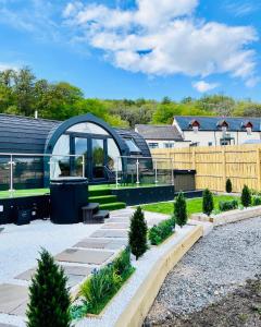 a garden with a glass house with a fence at Mingarry Park in Acharacle