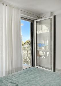 - une chambre avec une porte coulissante en verre et une fenêtre dans l'établissement Liza Apartments - Unit 1, à Shëngjin