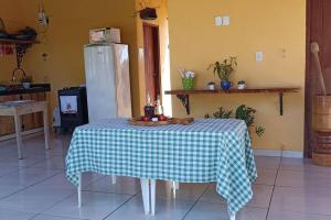 a table in a kitchen with a checkered table cloth on it at Chácara Beira Rio - NX -MT in Nova Xavantina