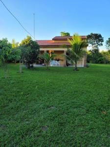 una casa con un patio verde delante de ella en Chácara Beira Rio - NX -MT, en Chavantina