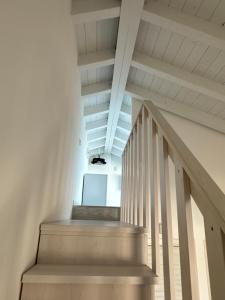 a staircase in a white room with white ceilings at Le Potager in Quartu SantʼElena +24 photos
