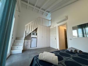 a room with a bed and a kitchen with stairs at Le Potager in Quartu SantʼElena
