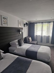 ein Hotelzimmer mit 2 Betten und einem Stuhl in der Unterkunft Posyrooms in Manchester