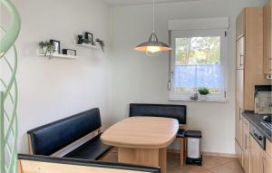 eine kleine Küche mit einem Holztisch und 2 Stühlen in der Unterkunft Ferienhaus Seeblick H in Herzsprung